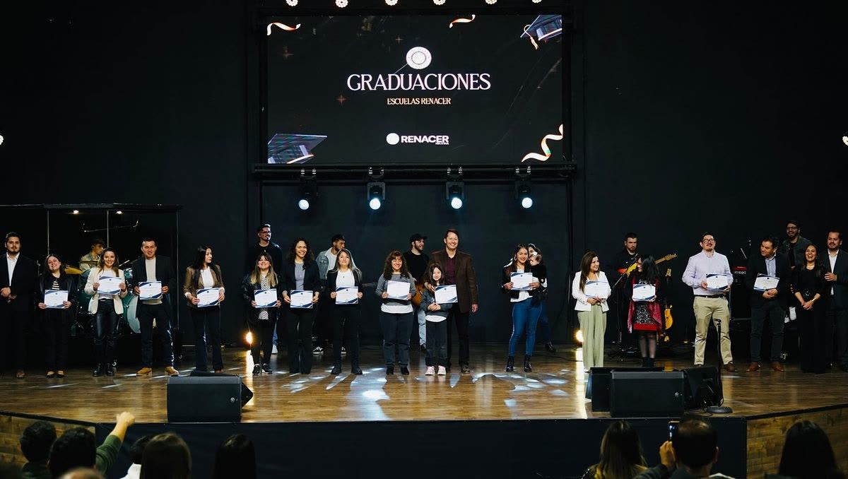 Graduados de la Escuela Renacer con su diploma, en el escenario del templo